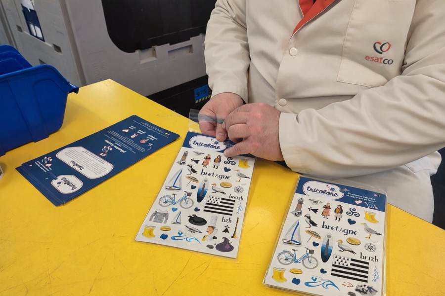 Mise sous sachet d'une planche de gommettes Bretagne à l'ESAT